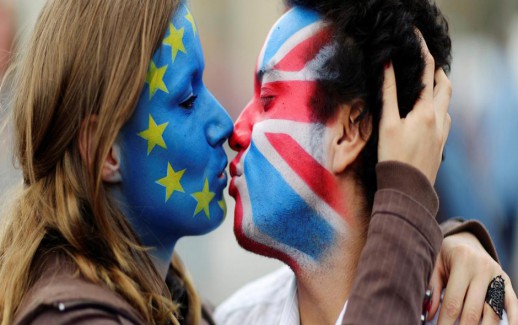 Two activists with the EU flag and Union Jack painted on their faces kiss each other in front of Brandenburg Gate to protest against the British exit from the European Union, in Berlin, Germany, June 19, 2016. REUTERS/Hannibal Hanschke