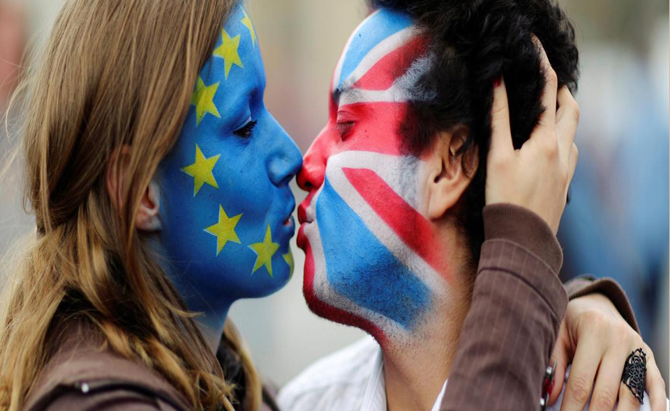 Two activists with the EU flag and Union Jack painted on their faces kiss each other in front of Brandenburg Gate to protest against the British exit from the European Union, in Berlin, Germany, June 19, 2016. REUTERS/Hannibal Hanschke