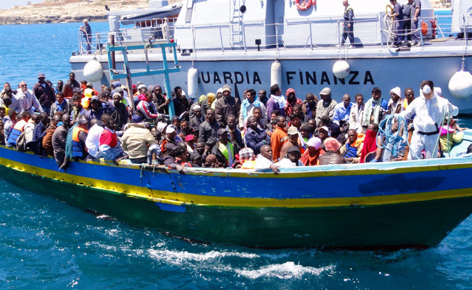 Lampedusa_Barca_di_migranti_viene_aiutata_ad_attraccare_dalla_nave_della_Guardia_di_Finanza