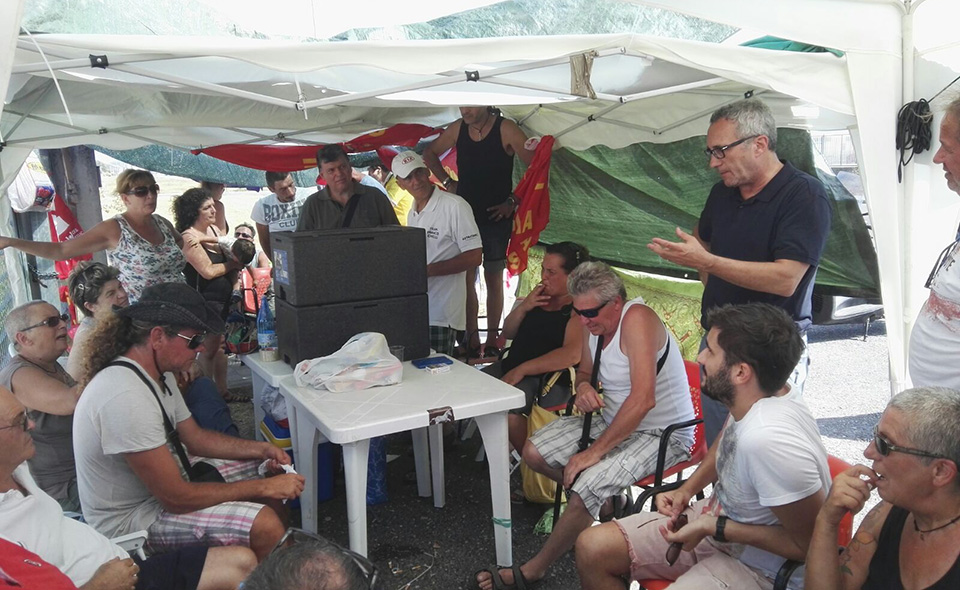 Nella foto: I lavoratori della TMM presidiano la fabbrica dichiarata in liquidazione